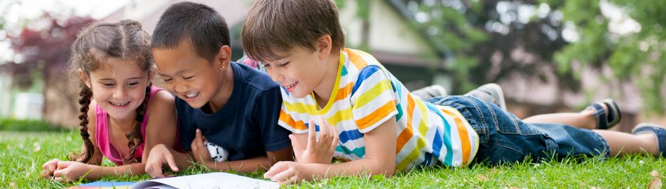 Kids reading on the grass Kids reading on the grass